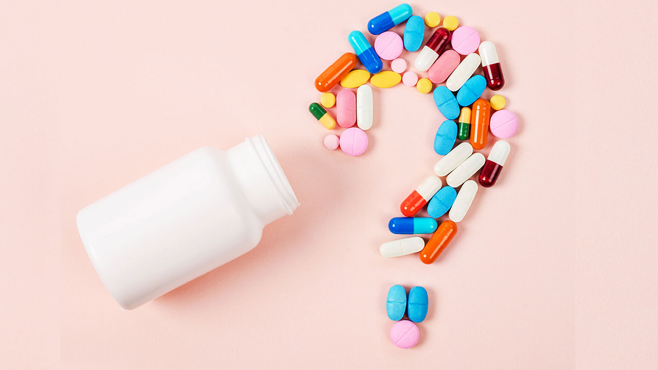 Pills layed out as a question mark on a table